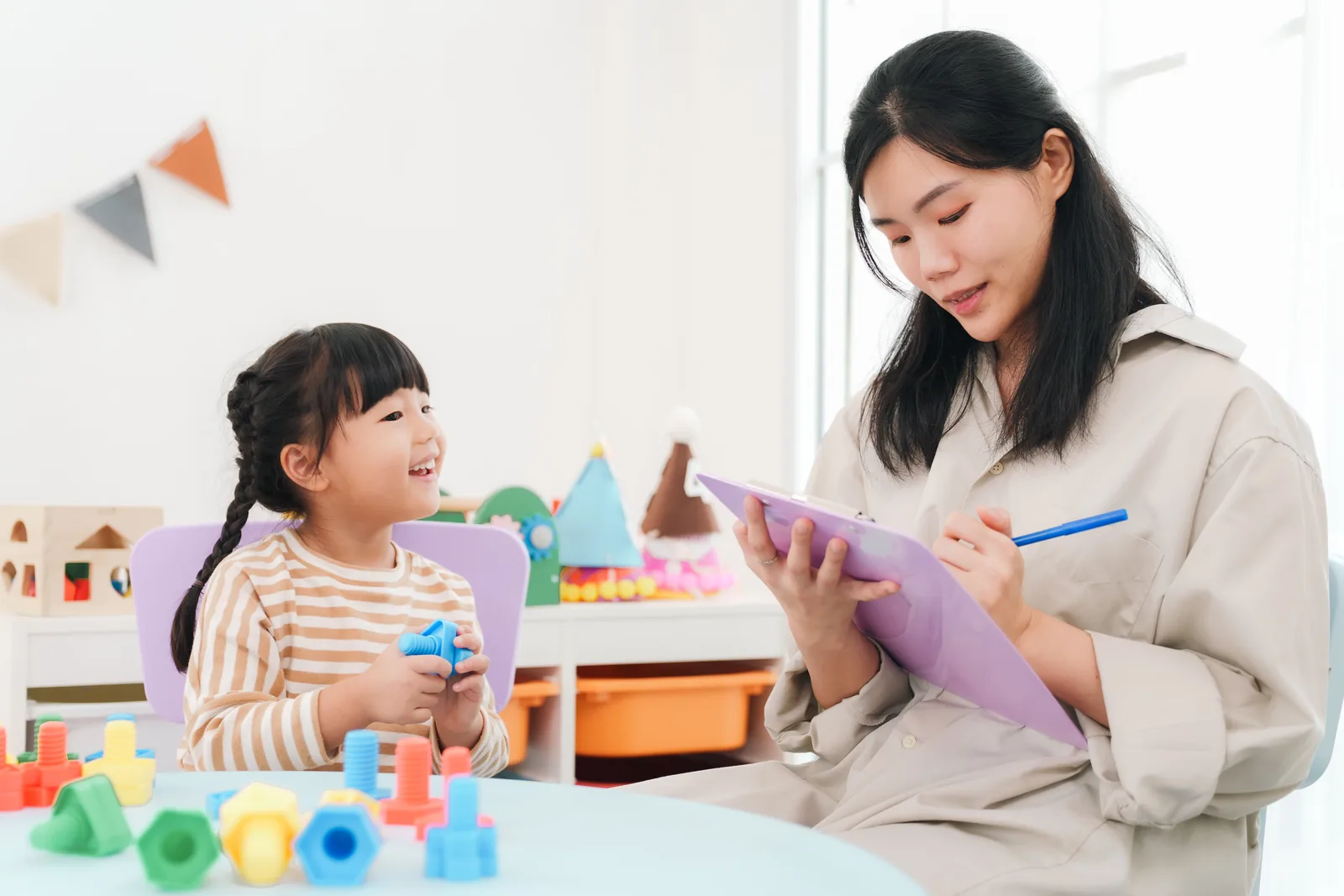 A Kids Club attendant signing a child in at a gym creche